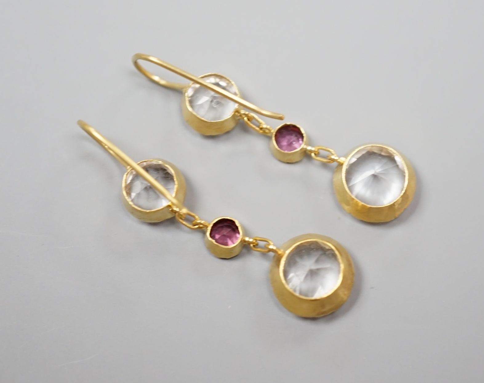 A pair of yellow metal, rock crystal and garnet? set three stone drop earrings, overall 37mm, gross 3.1 grams.